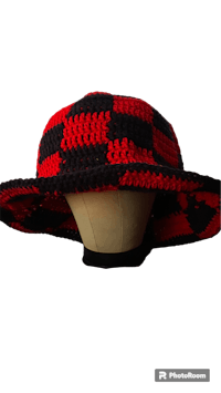 a red and black crocheted hat on a mannequin