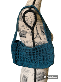 a blue crocheted bag on a mannequin mannequin