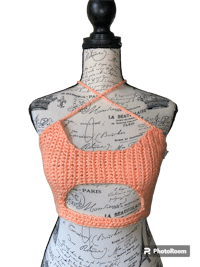 an orange crocheted top on a mannequin dummy